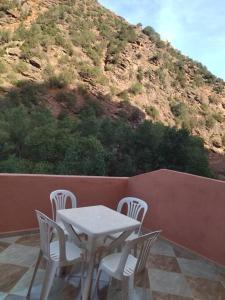 een tafel en stoelen op een balkon met een berg bij Enjoy Sunsets at this Lovely & Romantic Gest House in Marrakesh