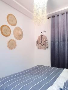 een slaapkamer met een bed en strohoedjes aan de muur bij Enjoy Sunsets at this Lovely & Romantic Gest House in Marrakesh