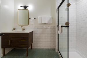a bathroom with a sink and a mirror and a shower at Signature Inn Oakland in Oakland