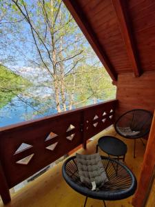 Hakuna Matata Lake House في يايتشه: شرفة مع طاولة وكراسي على شرفة
