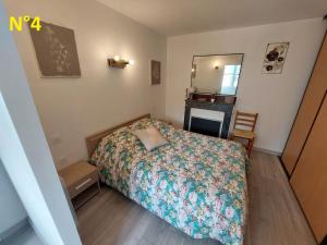 Dormitorio pequeño con cama y espejo en Les Cactus en Bagnères-de-Bigorre