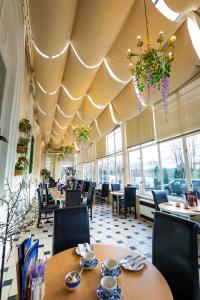 a restaurant with tables and chairs and a large ceiling at The Palace Hotel Buxton & Spa in Buxton