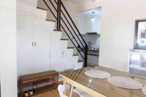 a dining room with a table and a staircase at Family-Friendly Cabin Hideaway, Alfonso Tagaytay in Alfonso +17 photos