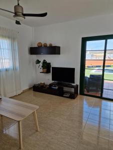 a living room with a flat screen tv and a table at TaraVilla in Tarajalejo