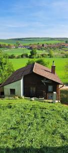 una casa en medio de un campo verde en Vinný sklep Bobule en Morkŭvky