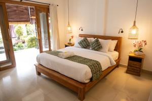 a bedroom with a large bed in a room at Liyer Spirit House in Ubud