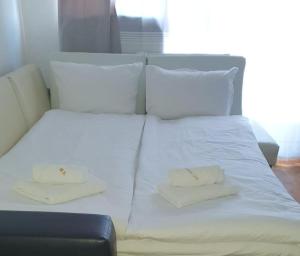 ein weißes Bett mit zwei weißen Kissen darauf in der Unterkunft Art studio Marina Cape-private host in Rawda