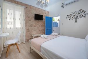 - une chambre avec un lit blanc et une porte bleue dans l'établissement gdk house in the heart of Aegina, à Égine