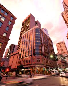 un grand bâtiment dans une rue de la ville avec des bâtiments dans l'établissement Metro Hotel Marlow Sydney Central, à Sydney