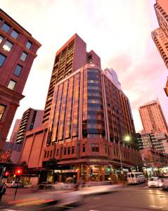 een hoog gebouw in een stadsstraat met gebouwen bij Metro Hotel Marlow Sydney Central in Sydney