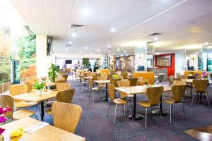 a dining room with tables and chairs in a restaurant at Metro Hotel Marlow Sydney Central in Sydney