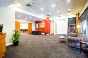 an office lobby with a couch and a table at Metro Hotel Marlow Sydney Central in Sydney