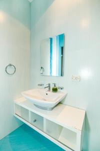La salle de bains blanche est pourvue d'un lavabo et d'un miroir. dans l'établissement Apartment ProDeLuxe, à Baku