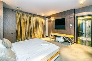 - une chambre avec un lit, un bureau et une télévision dans l'établissement Apartment ProDeLuxe, à Baku