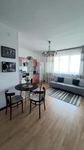 - un salon avec une table, des chaises et un canapé dans l'établissement Апартаменты с видом на горы, à Almaty