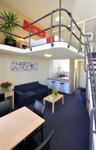 salon z łóżkiem na podwyższeniu i kuchnią w obiekcie Metro Apartments On Darling Harbour w mieście Sydney