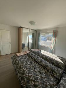 1 Schlafzimmer mit 2 Betten und einem großen Fenster in der Unterkunft Lovely 2 bedroom apartmen with free parking in Bergen
