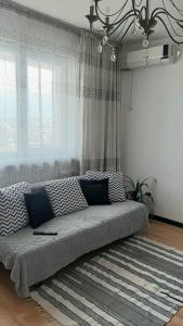 - un canapé dans le salon doté d'une grande fenêtre dans l'établissement Апартаменты с видом на горы, à Almaty