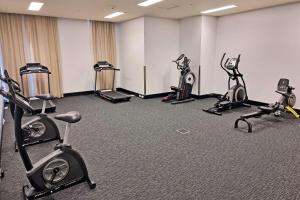 a gym with several treadmills and exercise bikes at Metro Advance Apartments & Hotel in Darwin