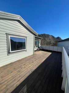 a wooden deck next to a house at Lovely 2 bedroom apartmen with free parking in Bergen
