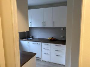 eine Küche mit weißen Schränken und einer Arbeitsplatte in der Unterkunft Lovely 2 bedroom apartmen with free parking in Bergen