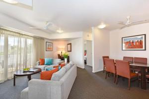 - un salon avec un canapé et une table dans l'établissement Metro Advance Apartments & Hotel, à Darwin
