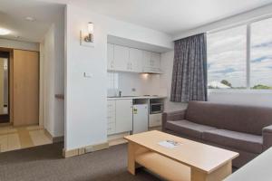 een woonkamer met een bank en een tafel bij Metro Hotel Perth in Perth