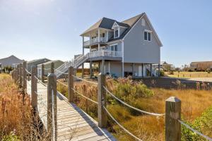 a house on the beach with a wooden boardwalk at Downeast Retreat home in Straits