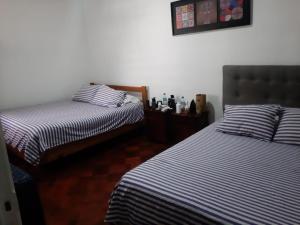 a bedroom with two beds with striped sheets at Atacama Hostel Backpackers in Santiago