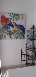 a painting of parrots on the wall of a room at Studio Central in Canet-en-Roussillon