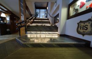 a set of stairs in a building with a sign on the wall at Hotel lo Stambecco in Breuil-Cervinia