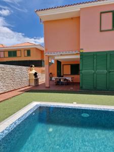 a villa with a swimming pool in front of a house at TaraVilla in Tarajalejo