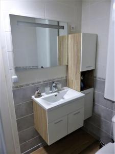 La salle de bains est pourvue d'un lavabo et d'un miroir. dans l'établissement Studio privée de 24m2 à 20 min de Puy du fou, à Vendrennes