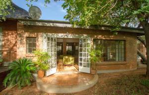 a brick house with a patio with a chair at Beautiful home overlooking a park - 2097 in Victoria Falls