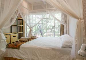 a bedroom with a canopy bed with a window at Beautiful home overlooking a park - 2097 in Victoria Falls