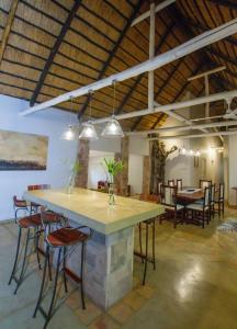 a large room with tables and chairs and a stone counter at Beautiful home overlooking a park - 2097 in Victoria Falls