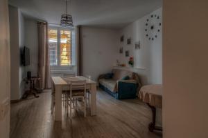 una pequeña sala de estar con una mesa y una cama en Corso Vittorio Emanuele 110c en Nápoles