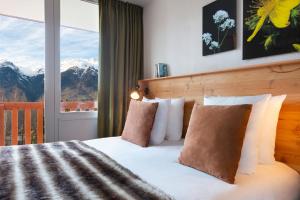 a bedroom with a bed with a view of mountains at SOWELL Family La Lauzière in Aime-La Plagne