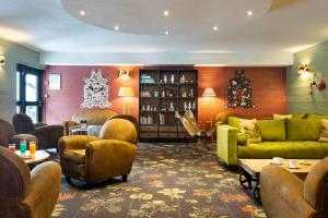 a living room with green couches and chairs at SOWELL Family La Lauzière in Aime-La Plagne