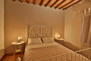 1 dormitorio con 1 cama con 2 mesas y 2 lámparas en CASTELLO - Home Sweet Home Tuscany, en Colle Val D'Elsa