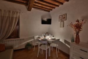 a dining room with a white table and chairs at CASTELLO - Home Sweet Home Tuscany in Colle Val D'Elsa