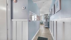 a hallway with white walls and a tile floor at Sunbird Sunsets in Panama City Beach