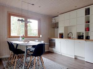 a kitchen with white cabinets and a table and chairs at Wald und Wohlsein in Beelitz