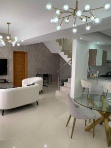 a living room with a white couch and a glass table at Lujoso PH en DT, área de trabajo y Gym, 1BR in Santo Domingo