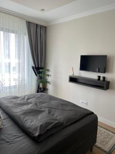 a bedroom with a bed with a flat screen tv on the wall at Belgrade Waterfront Escape 104 in Belgrade