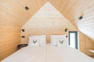 a bed in a room with a wooden ceiling at Cabino - Fresh Air Resort in Bovec