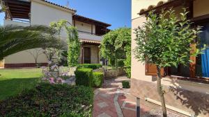 a house with a garden next to a building at Porto Thea Villa in Afytos in Afitos