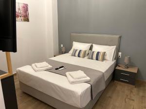 a bedroom with a large bed with towels on it at Technopolis Luxury Apartments in Athens