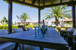 a long table with wine glasses on a patio at Porto Thea Villa in Afytos in Afitos
