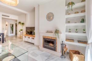 a living room with a fireplace and a table at Deluxe relax apartment with pool in Estepona